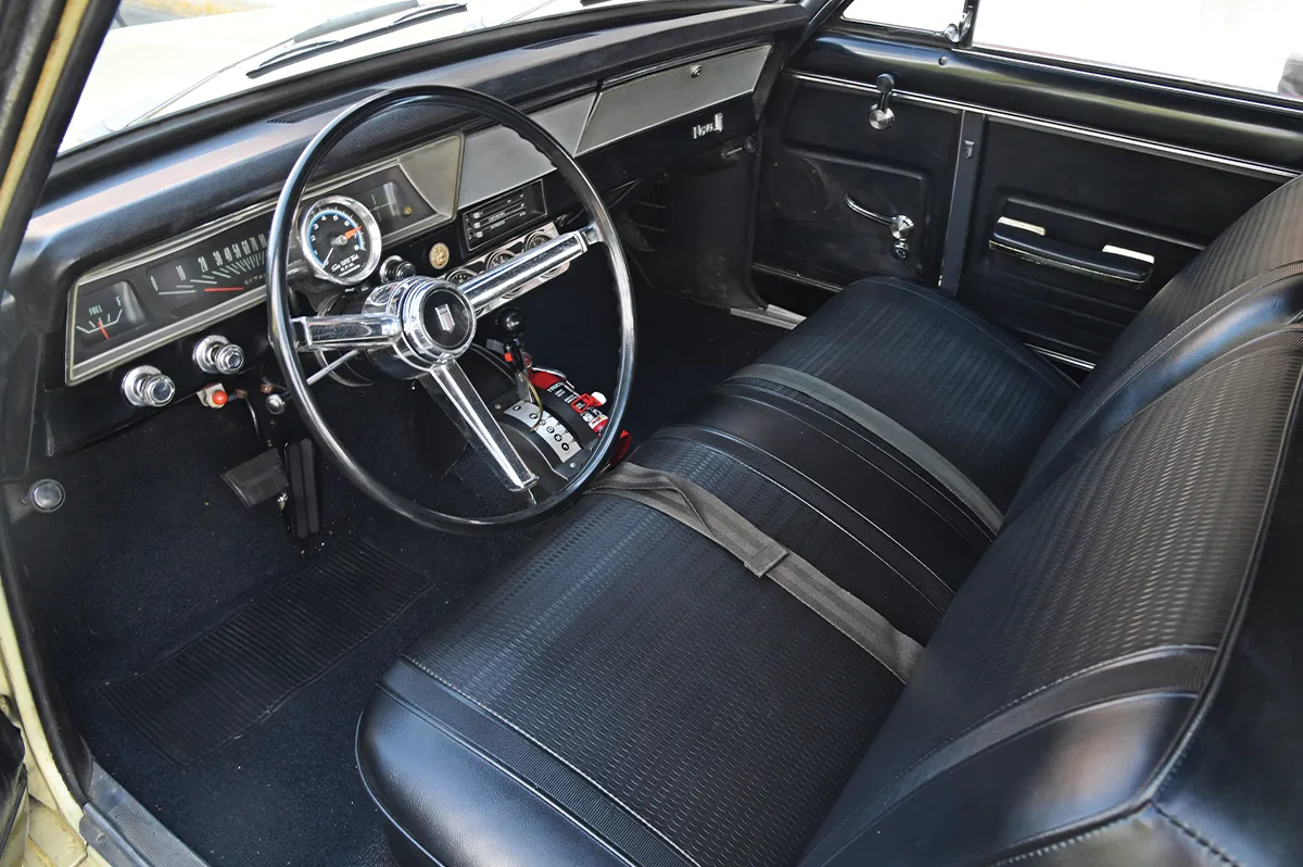 1967 Chevrolet Nova, interior shot with black bench seats and chrome-accented steering wheel for vintage appeal