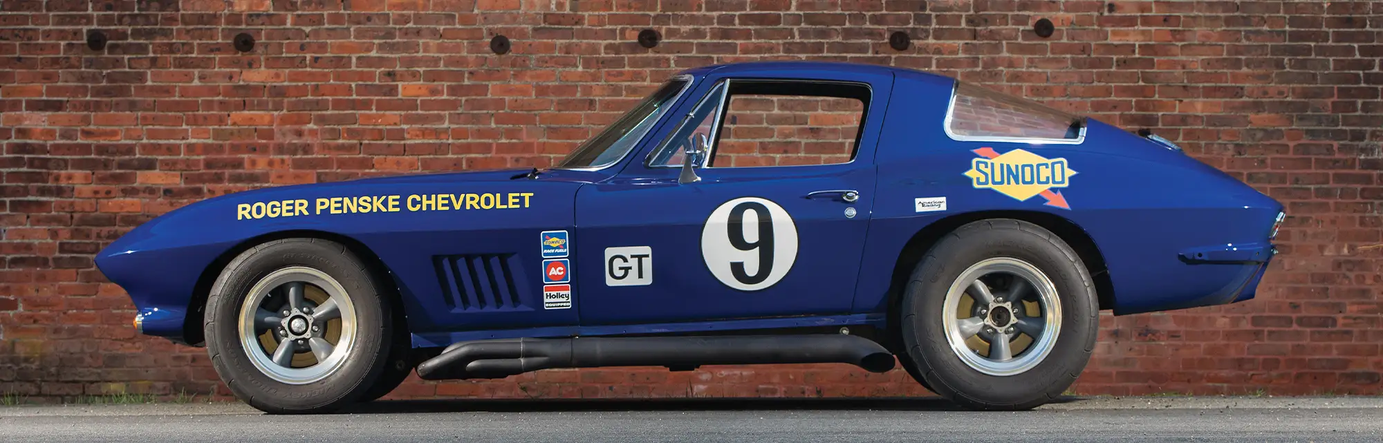 1966 Chevrolet Corvette, front view, blue, showcasing hood scoop, grille, and headlight details with a racing stance