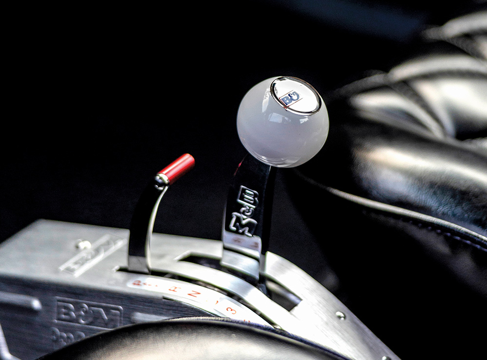 B&M shifter with white shift knob installed in a 1966 Chevy Nova for enhanced drag racing control