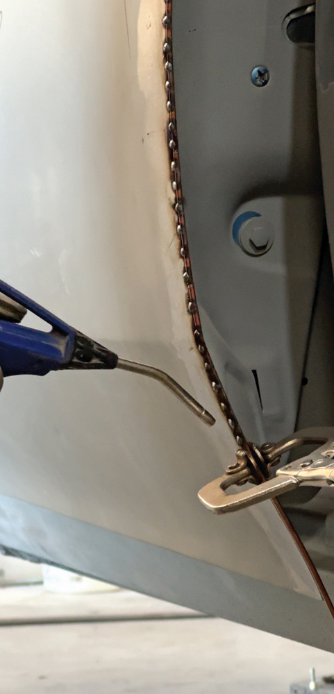 close-up of uniform tack welds clamped with copper for precise alignment