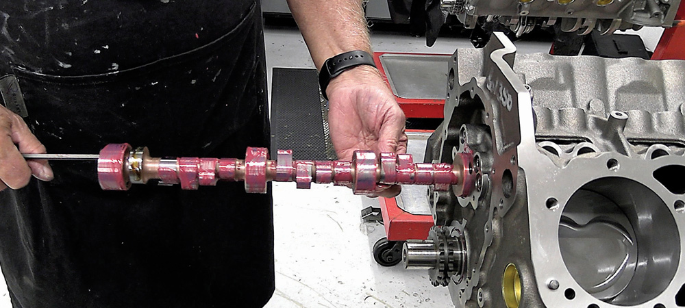 Technician installing a camshaft into the 424 small block engine with assembly lube applied