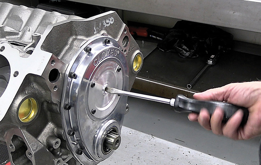 Polished front timing cover being secured on the 424 small block engine block