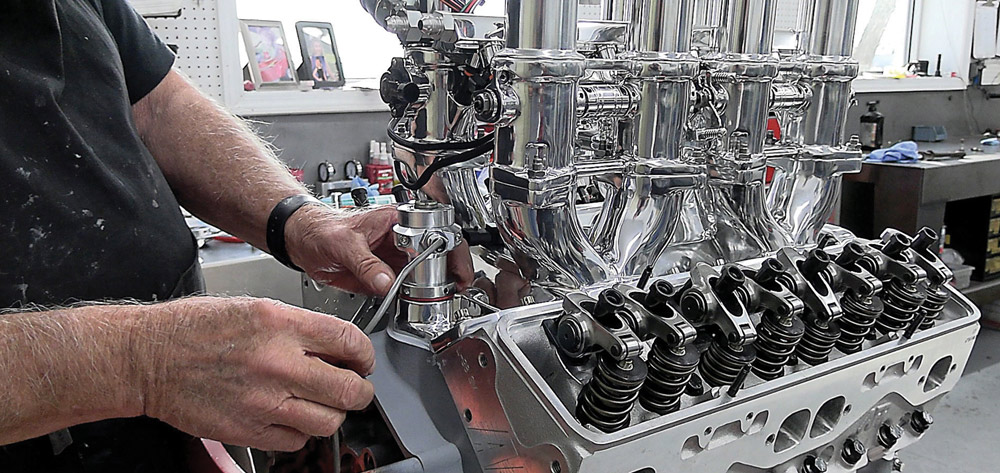 Technician adjusting valves and inspecting rocker arms on the 424 small block engine