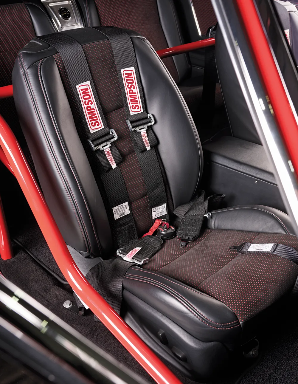 1965 Chevrolet Impala SS racing seat with Simpson harness, custom upholstery, and integrated roll cage in red