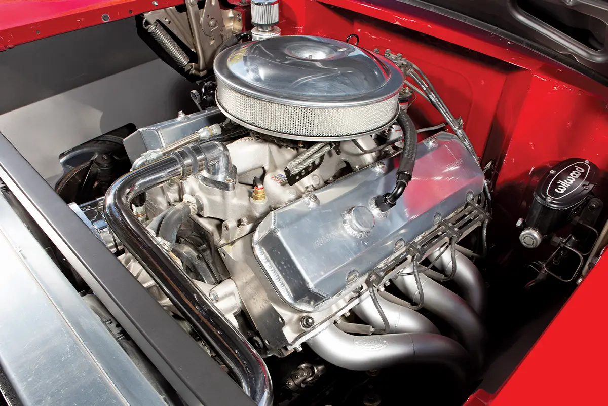 1957 Chevy High-performance engine bay featuring an aluminum intake manifold, polished headers, and Wilwood master cylinder