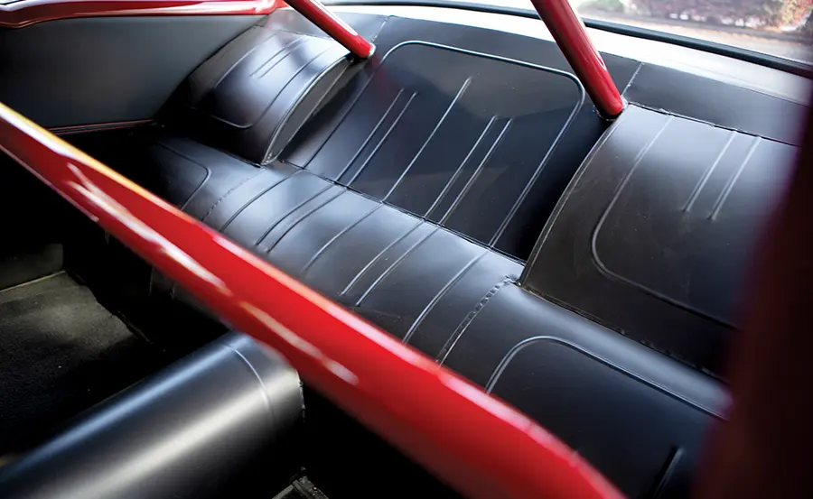 1957 Chevrolet Bel Air rear seat in black leather with a red roll cage for a race-inspired interior