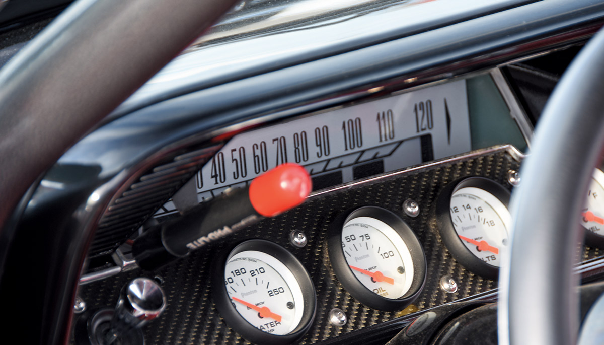 1961 Chevrolet Impala race gauges with carbon fiber panel, AutoMeter dials, and factory speedometer for performance monitoring