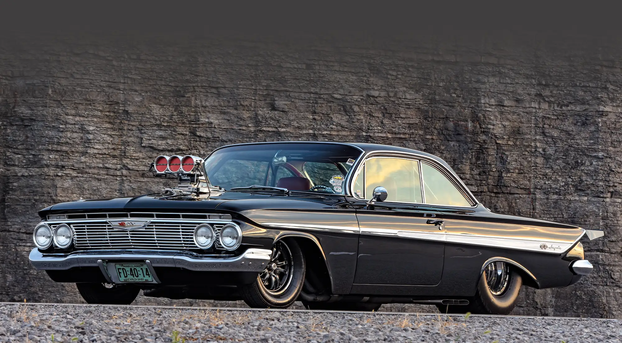 1961 Chevrolet Impala Pro Street with a menacing black paint job, low stance, and massive rear tires for drag racing performance