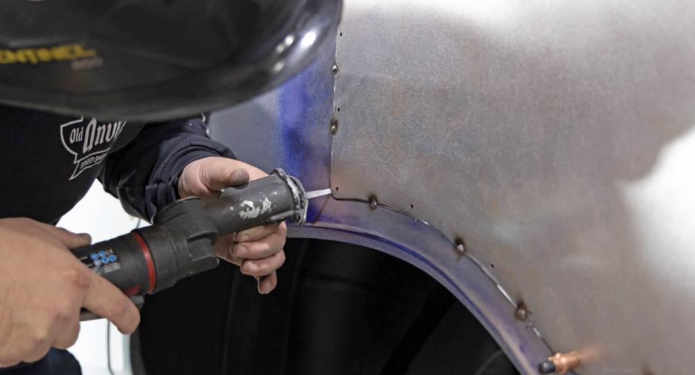 fabricator uses a pneumatic punch to prepare the panel for final welding and seamless blending