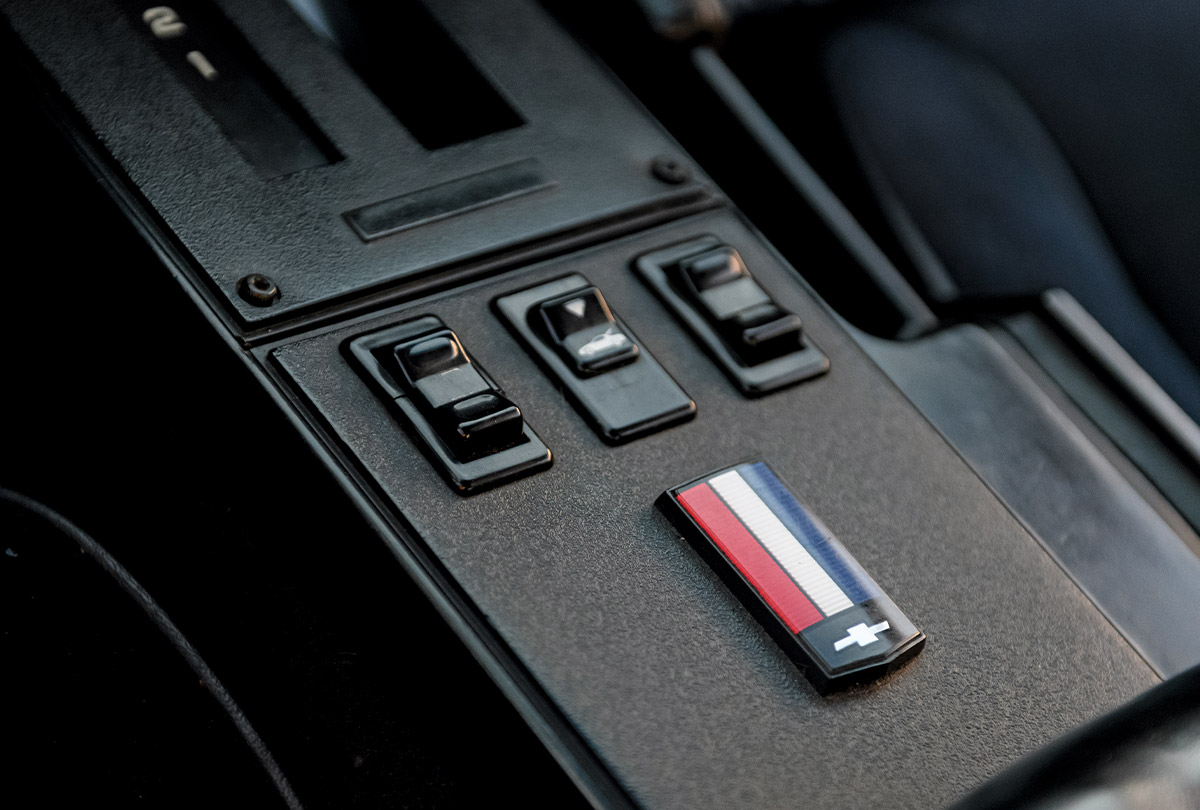 1986 Camaro IROC-Z center console with classic power window controls and tri-color Chevy emblem