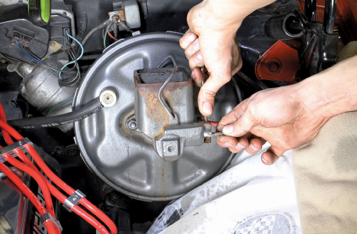 Mechanic disconnecting brake lines from a rusted master cylinder
