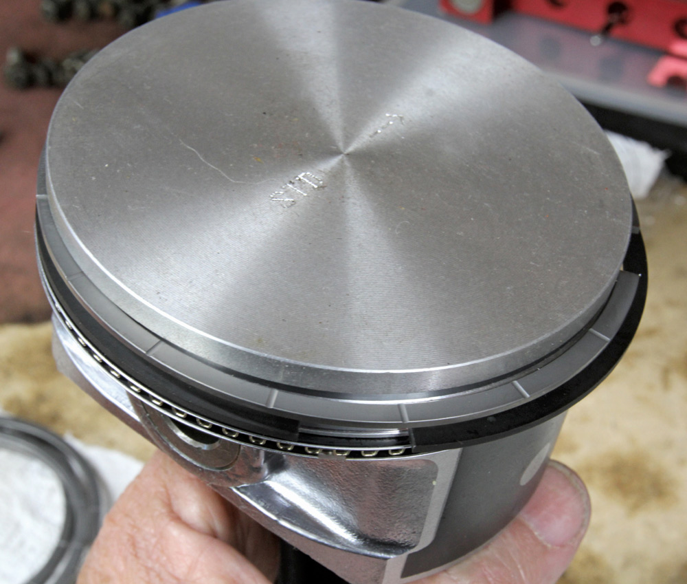 Flat-top forged piston for LS engine with Total Seal rings, designed for high-compression performance builds