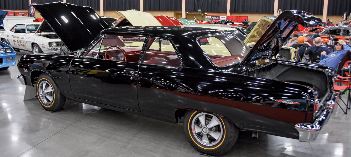 1966 Chevrolet Chevy II Nova with black paint, red interior, and period-correct trim