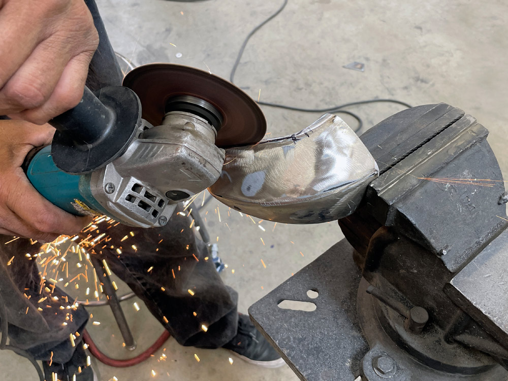 1969 Camaro bumper corner trimmed with angle grinder for precision contouring