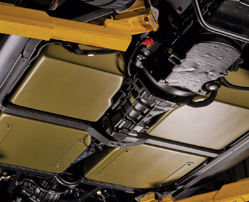 Underside view of a 1963 Corvette reveals four large, rectangular, olive colored battery packs
