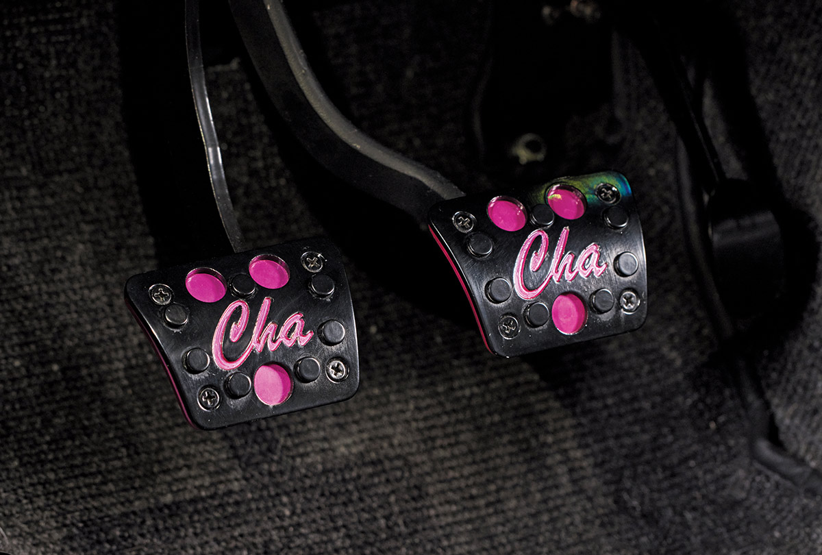 close-up view of two black car pedals with "Cha" in pink script and pink accents
