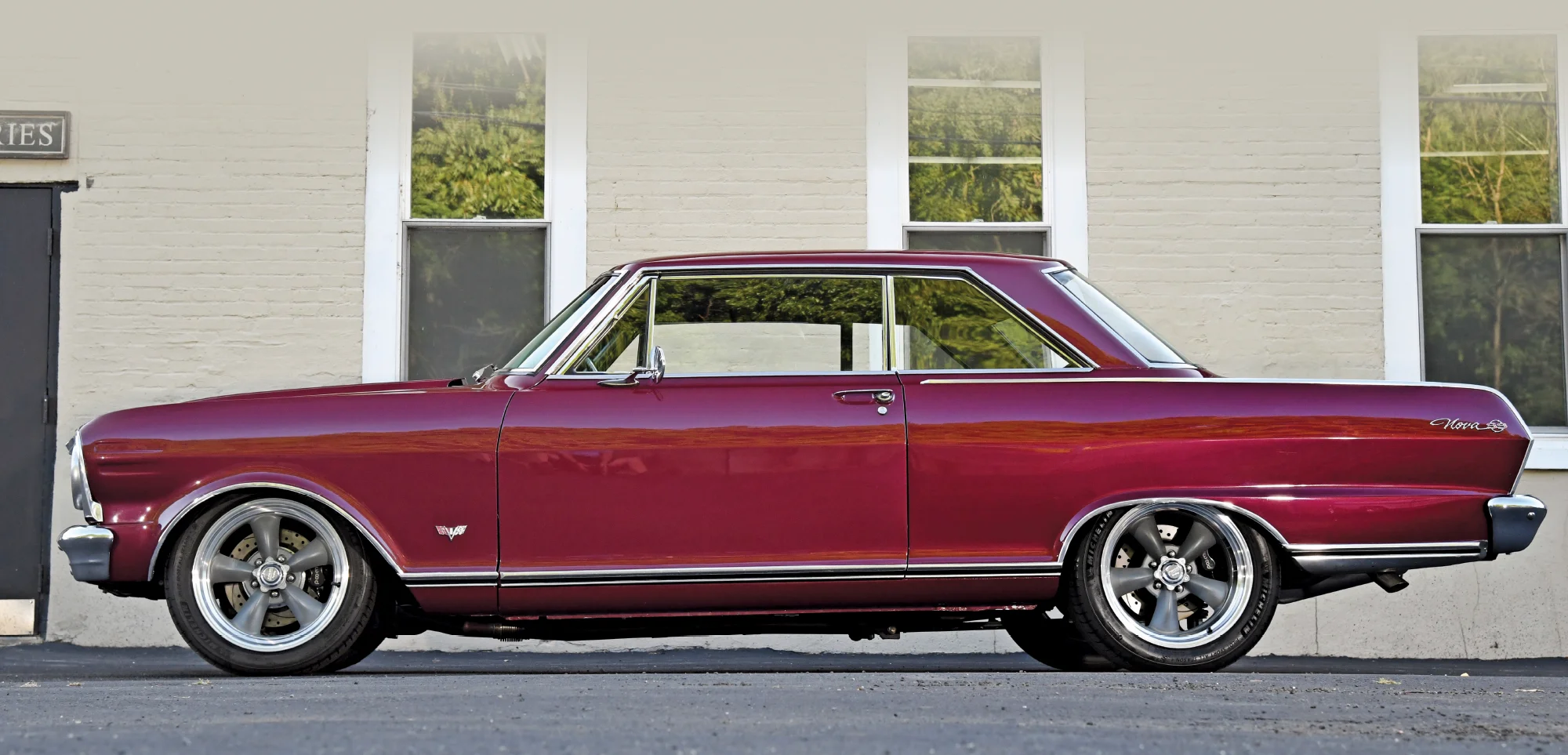 1965 Chevy Nova side profile in burgundy with modern five-spoke wheels and lowered look