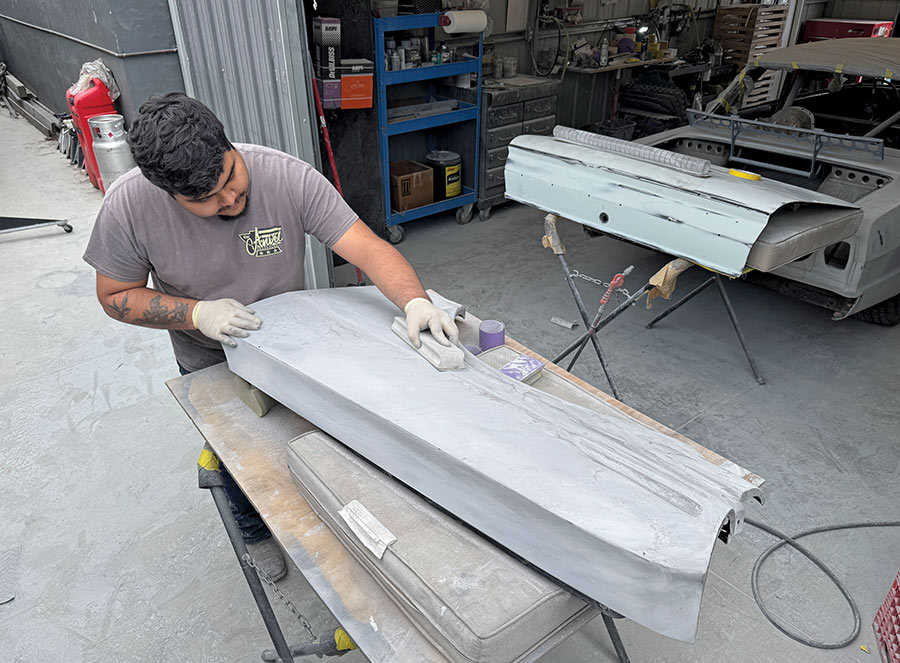 Bodyman block sanding primed 1963 Chevy Nova door skin