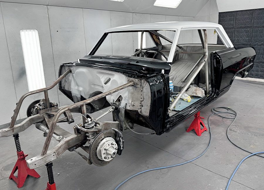 1963 Chevy Nova in booth black sides white roof chassis exposed