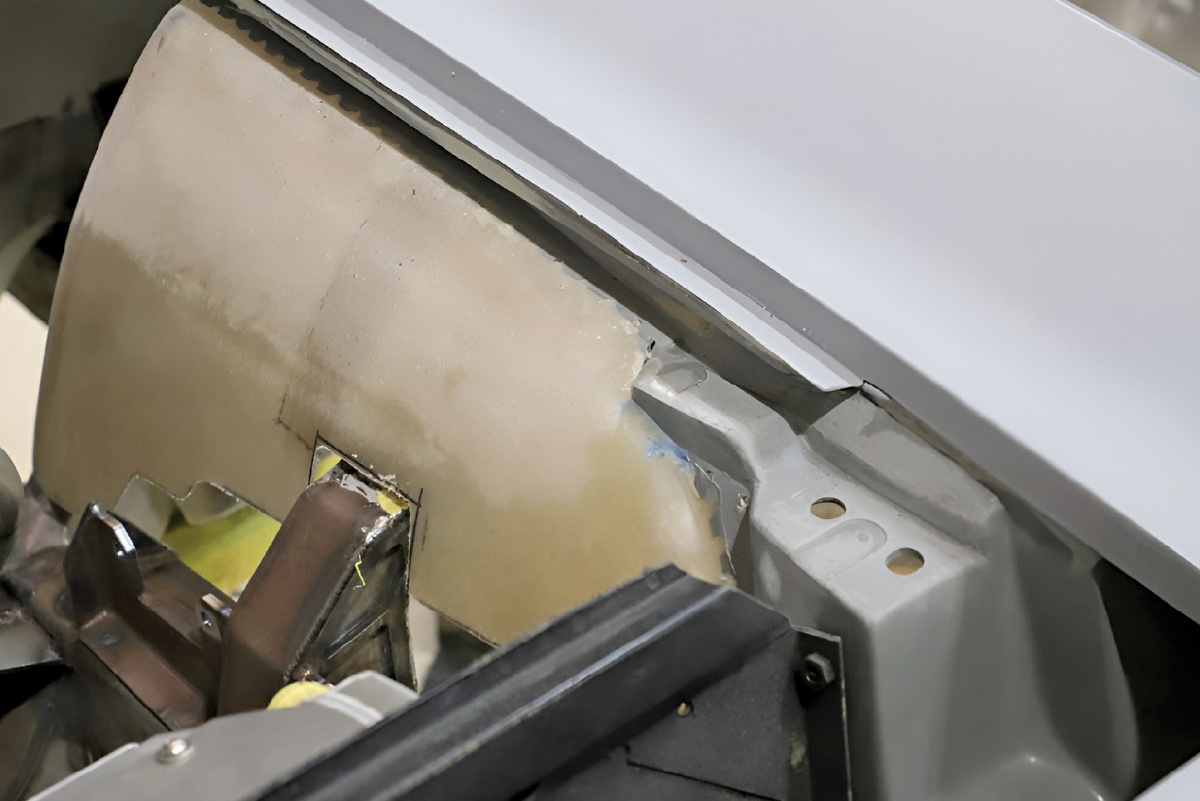 Close-up of internal body panels and metal fabrication inside a car's engine bay.