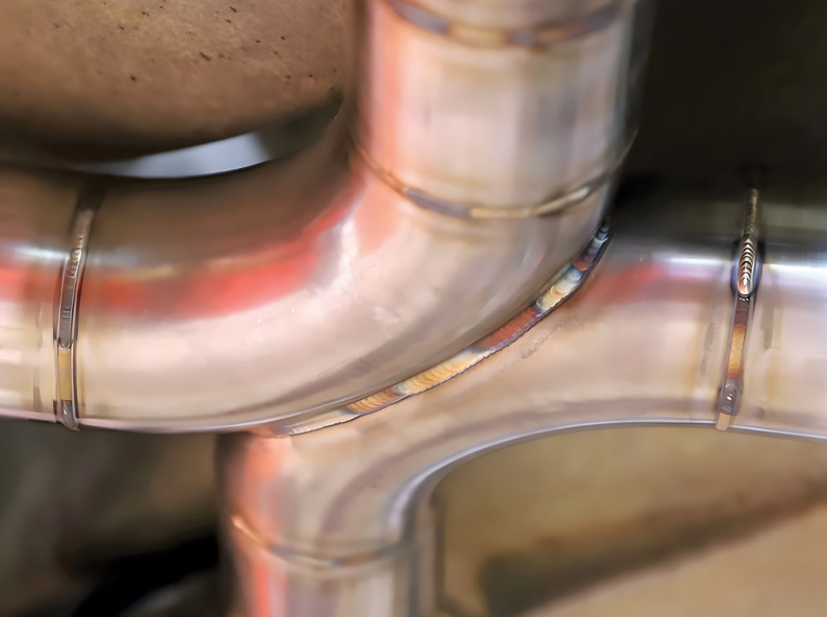 Extreme close-up of a precise weld on a stainless steel exhaust joint.