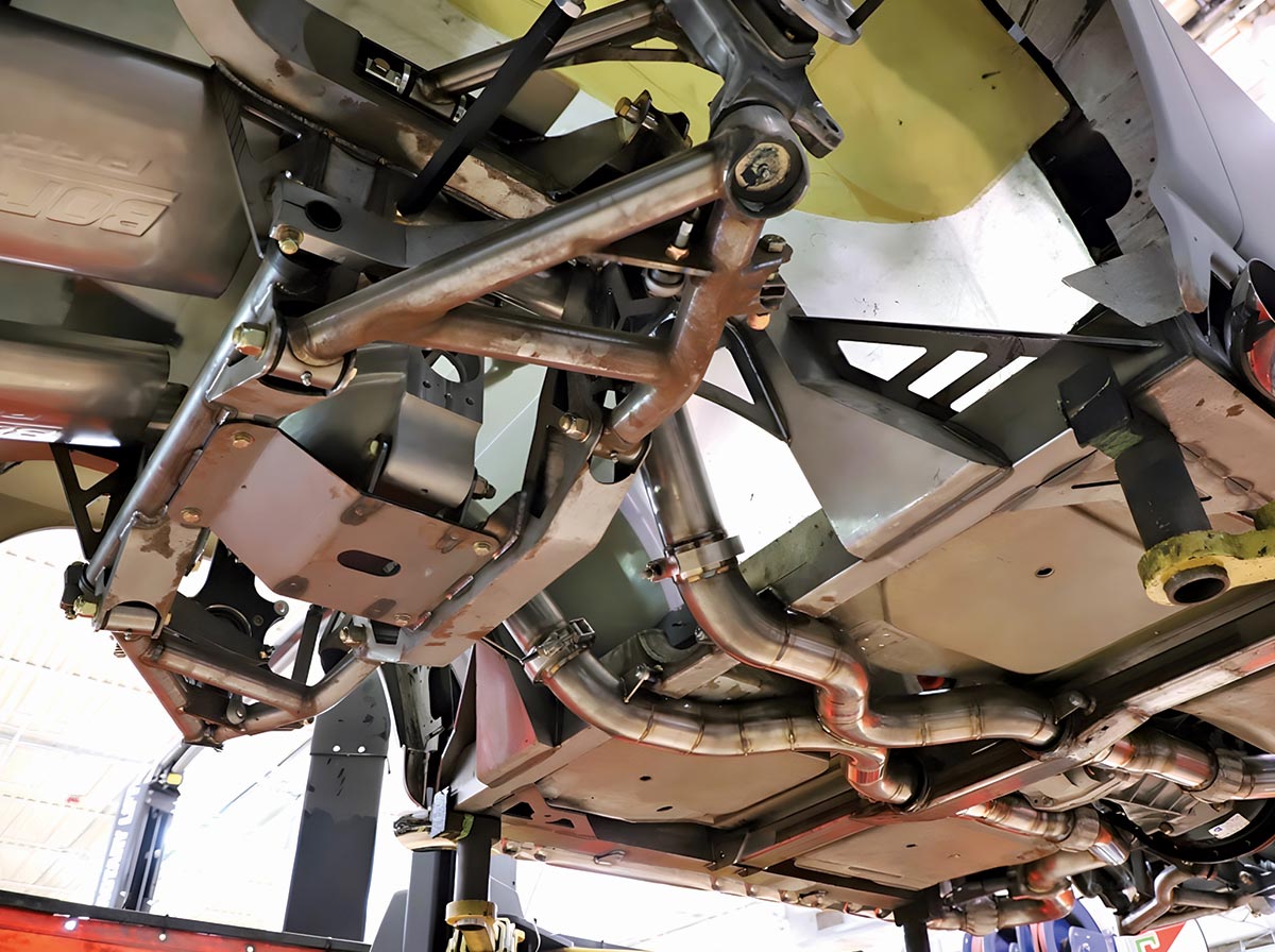Wide underside view of the chassis showing the exhaust routing and rear suspension components.