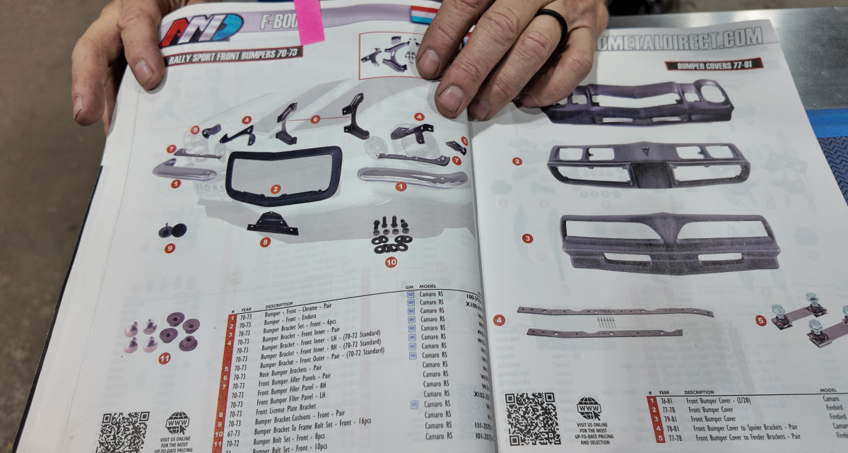 Hands hold an open catalog showing "Rally Sport Front Bumpers 70-73" and various car part diagrams.