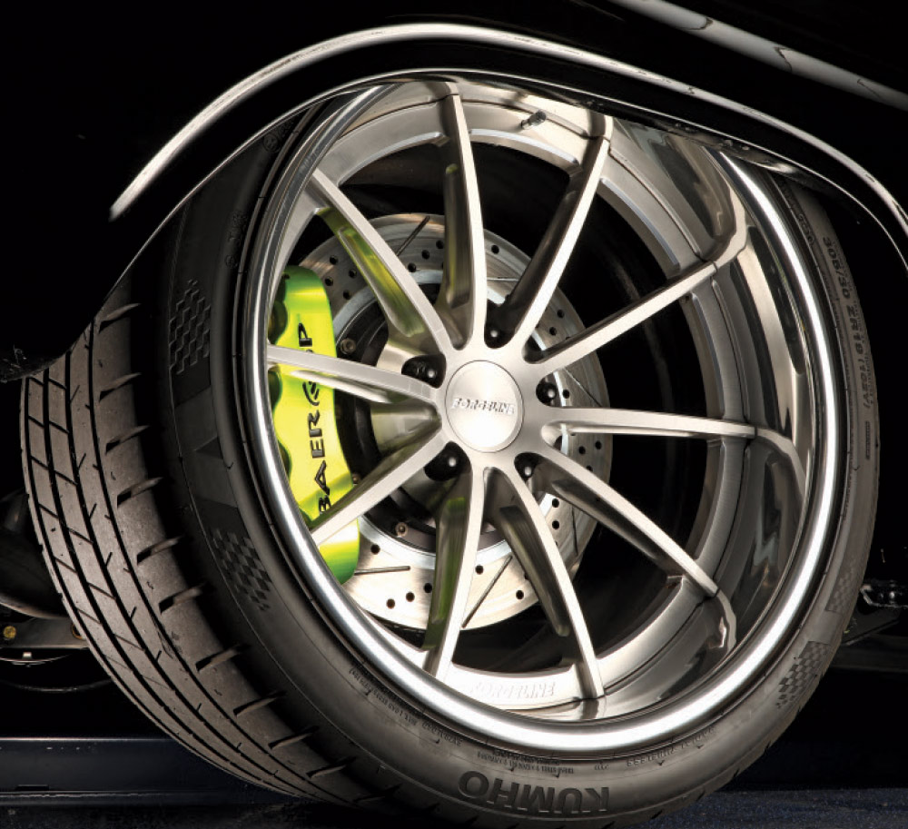 Close-up of a Forgeline wheel with green Baer brake caliper.