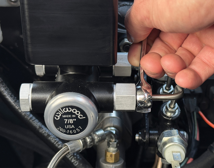 Adjusting brake line fitting with wrench.