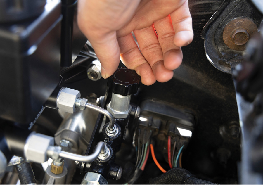 Hand turning the proportioning valve adjustment knob.