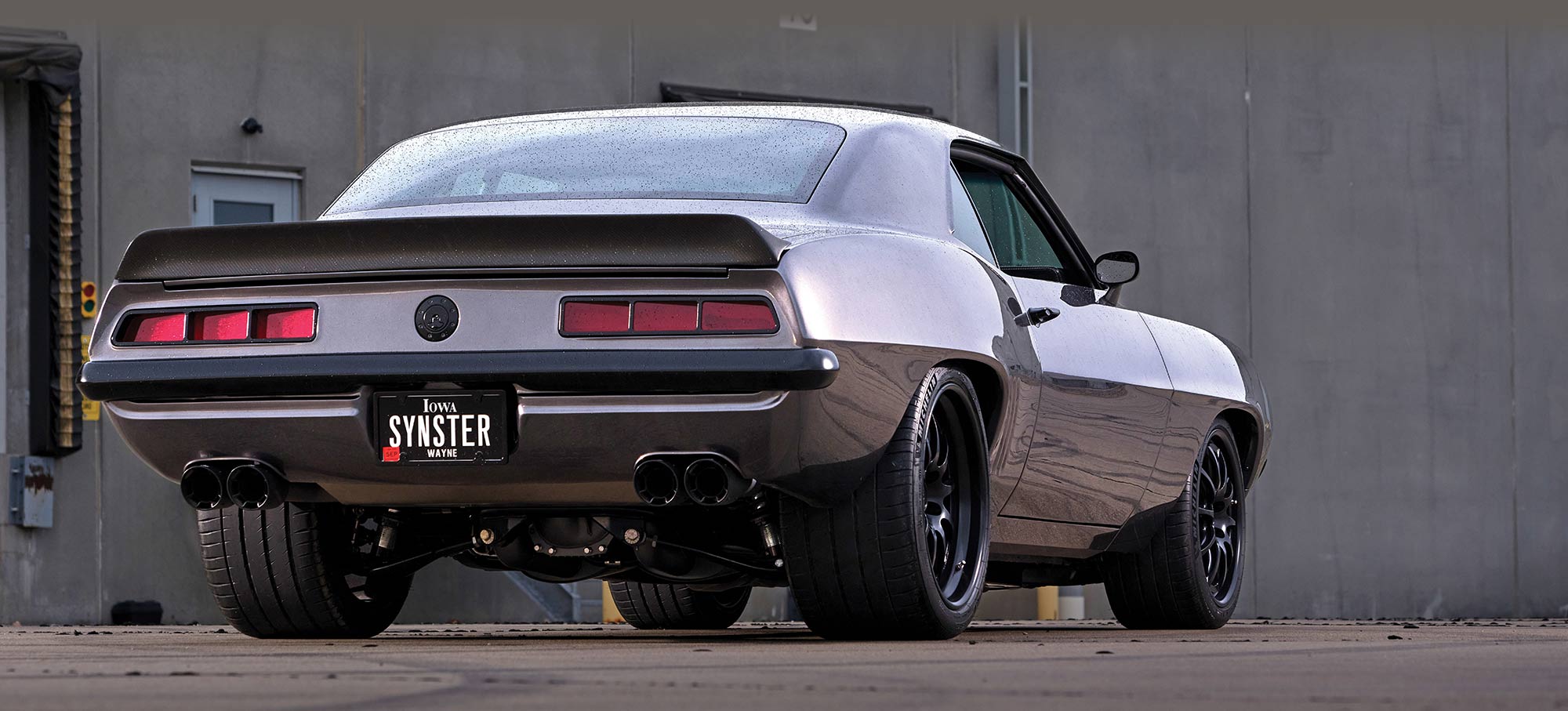 Rear three-quarter view of the Camaro with "SYNSTER" license plate.
