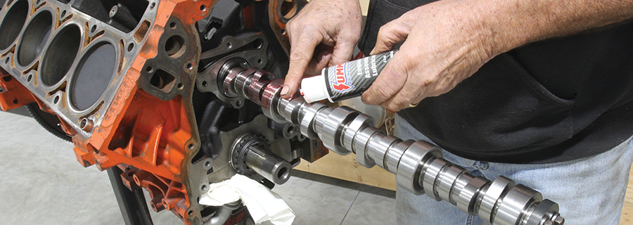 Applying assembly lube to camshaft lobes.