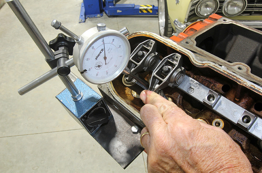 Measuring piston-to-valve clearance with dial indicator.