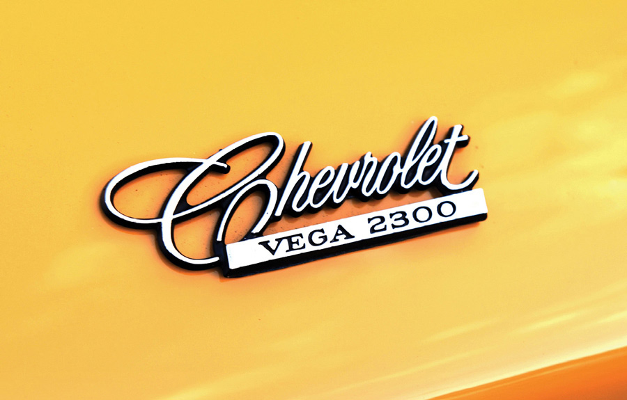 Close-up of Chevrolet Vega 2300 emblem on yellow paint