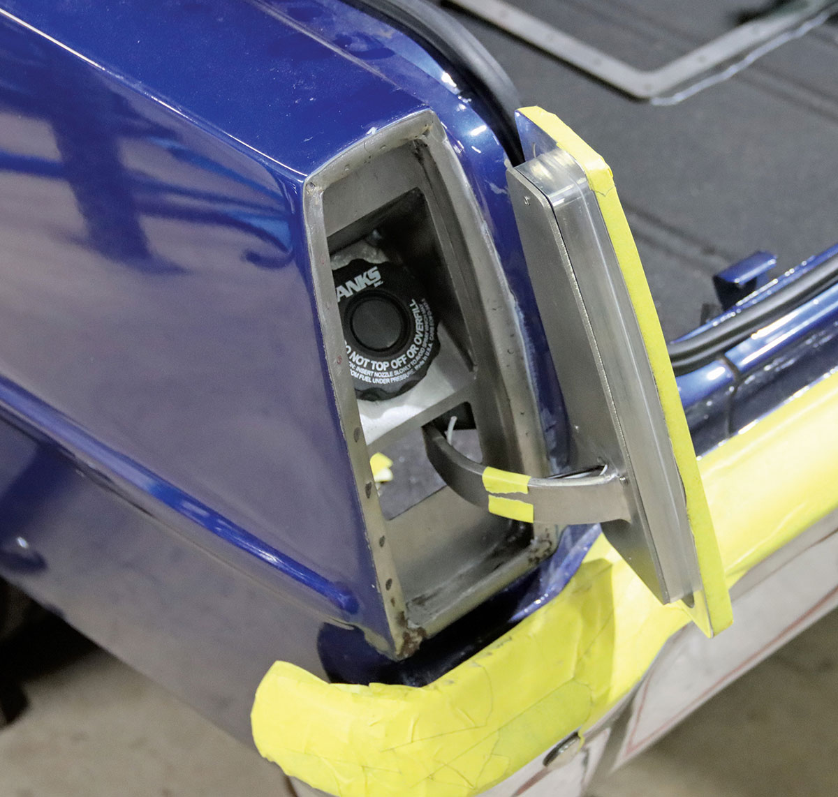 Taillight housing swung open to reveal hidden gas filler.
