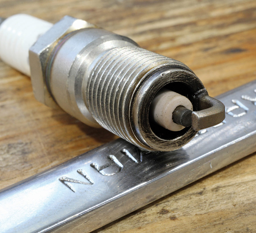 Close-up of a spark plug displaying a healthy light tan insulator color.
