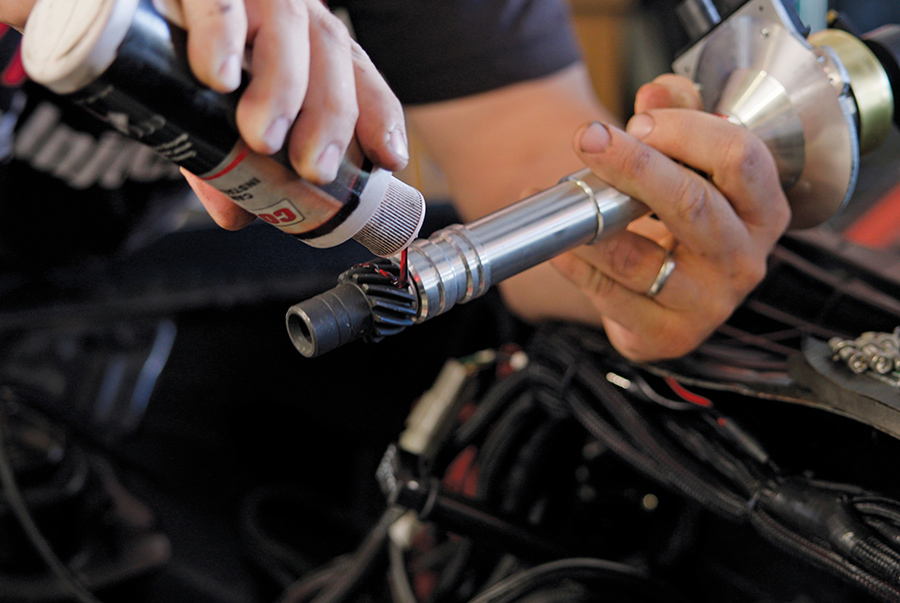 Applying assembly lube to a distributor gear.