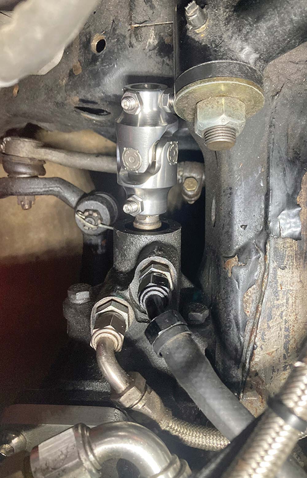 Polished U-joint connected to the power steering box.