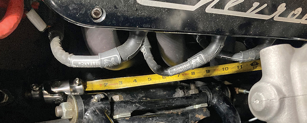 Measuring distance between U-joints with a yellow tape measure.