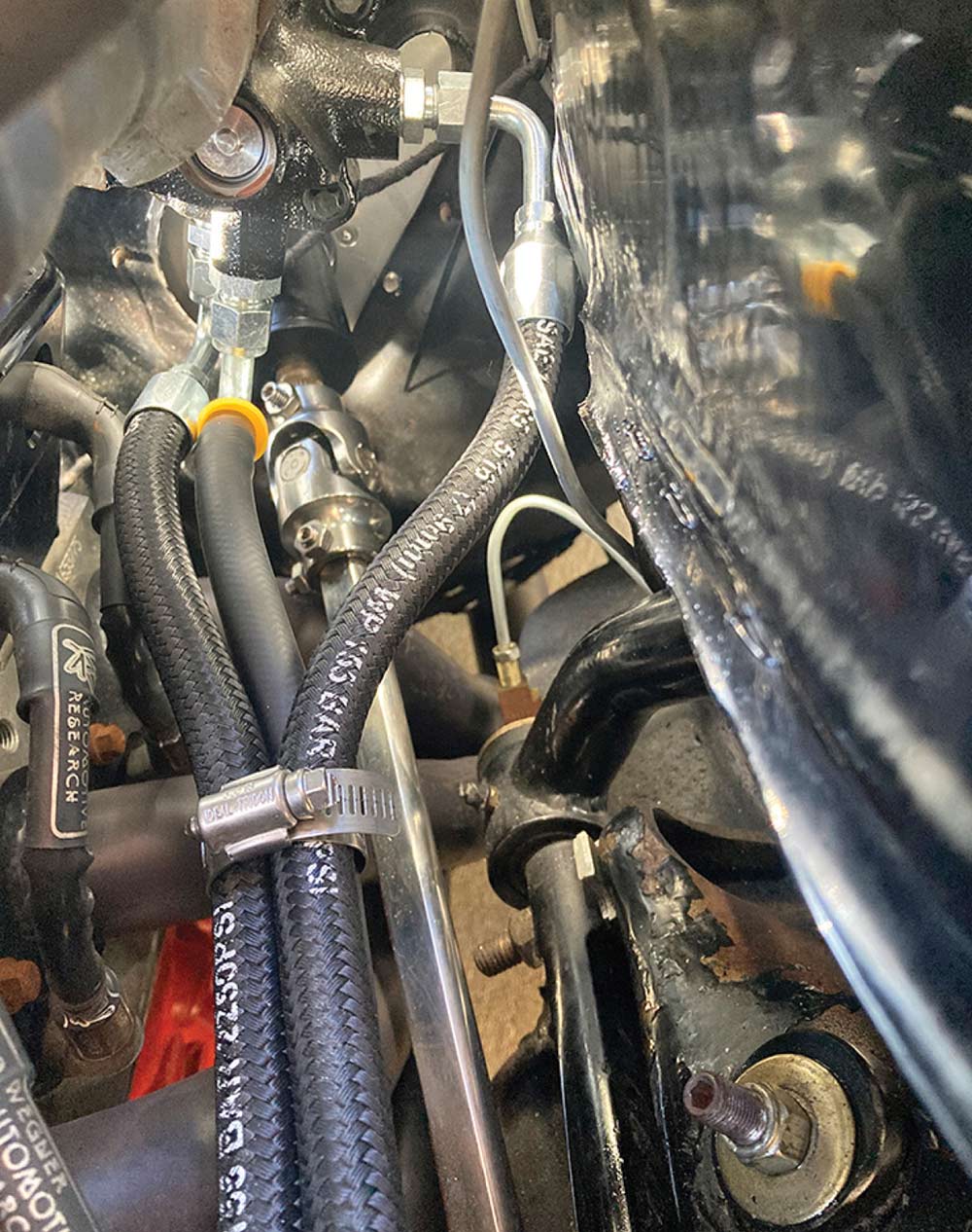 Detail of hydraulic hoses routed near the steering column.