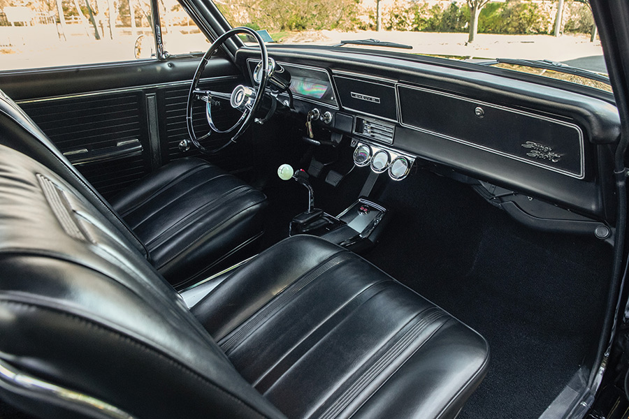 Interior view of a 1966 Chevy Nova with black vinyl bucket seats.