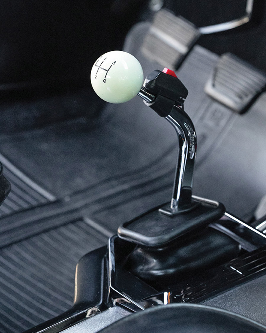 Detail of the Hurst shifter with a white four-speed knob.