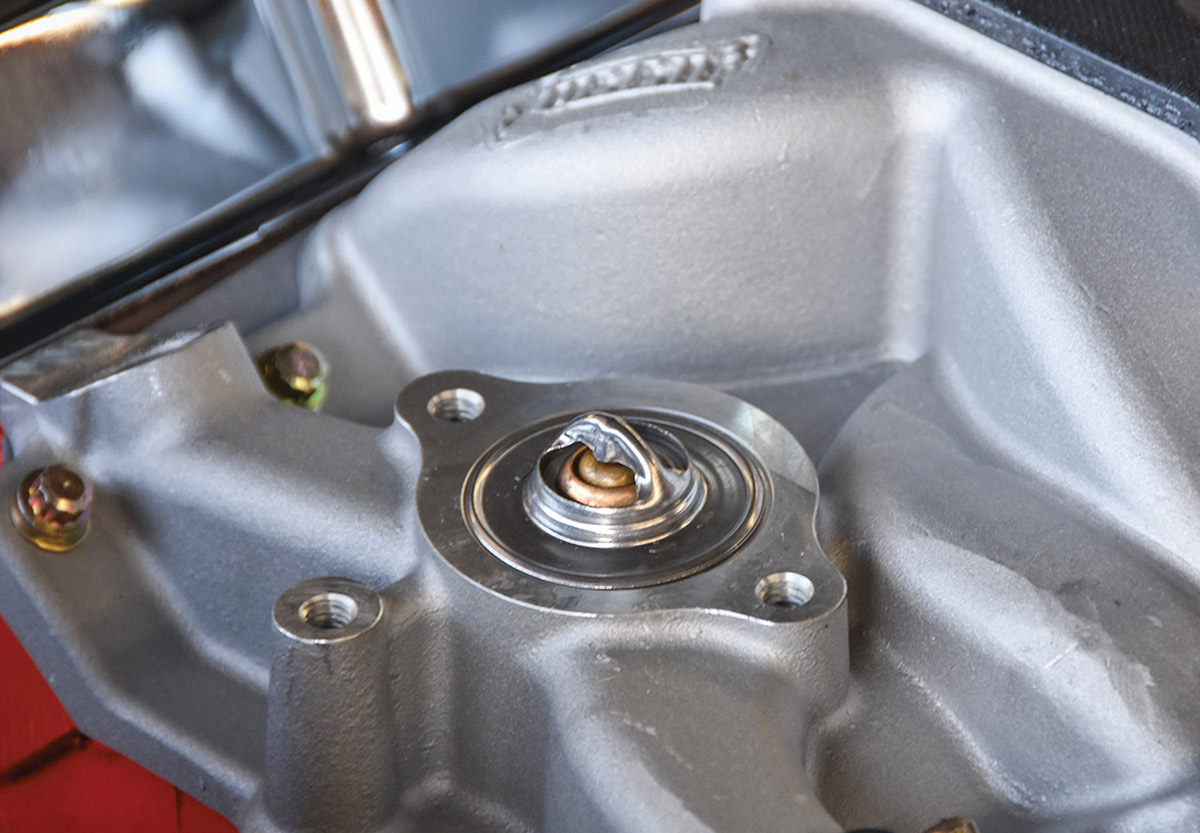 Installing a new thermostat into the intake manifold.