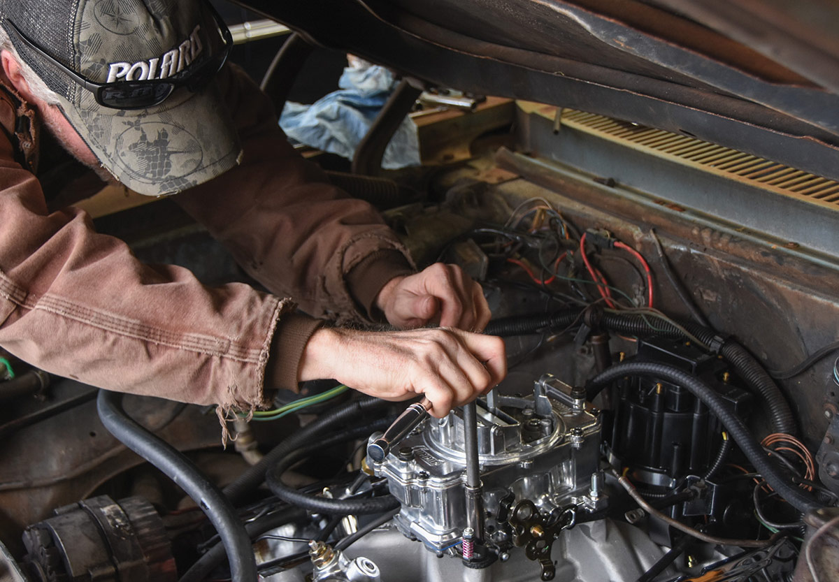 Tightening the carburetor mounting nuts on the studs.