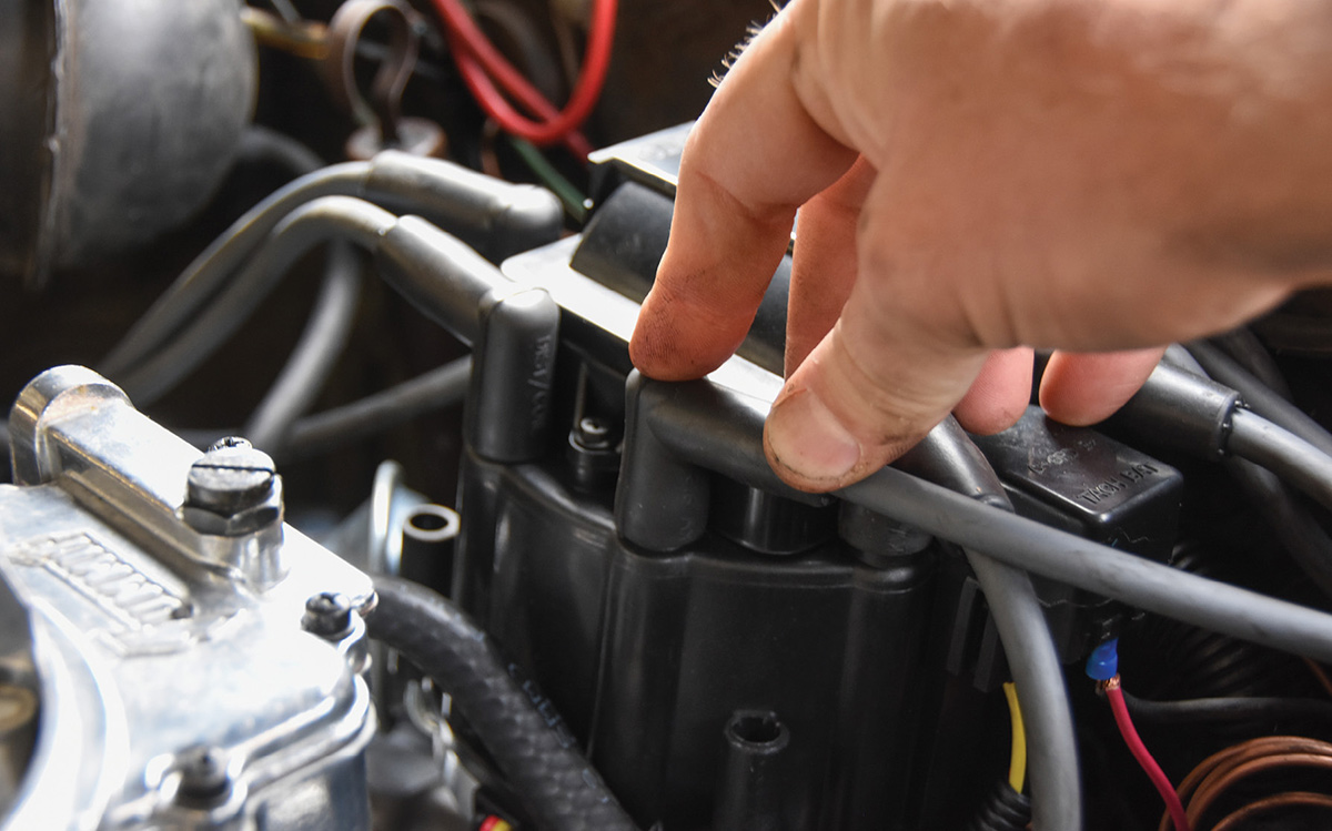 Snapping new spark plug wires onto the distributor.