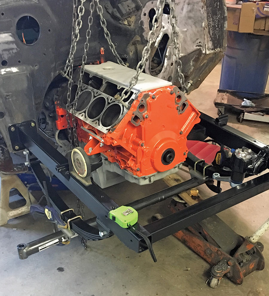 Orange engine block mounted on a black subframe.