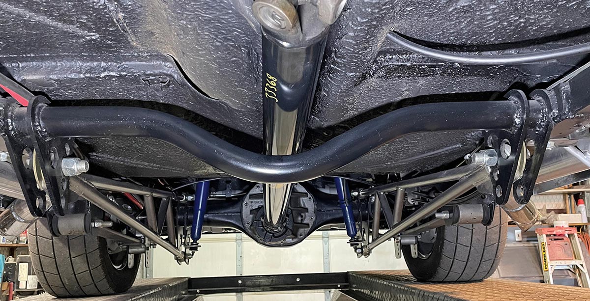 Rear axle with blue shocks and ladder bar suspension.