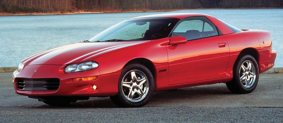 Red 1998 Camaro Z28 parked by a lake.