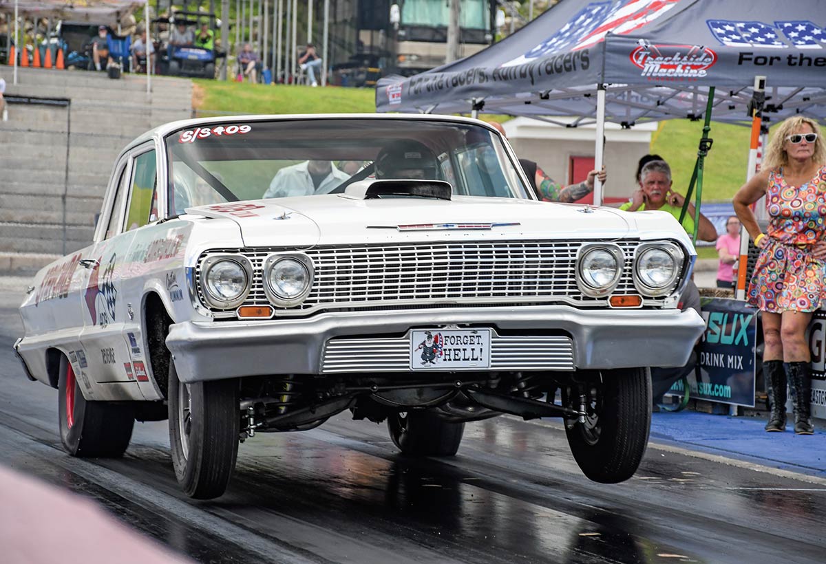 White 1963 Chevy gasser launching at the track.