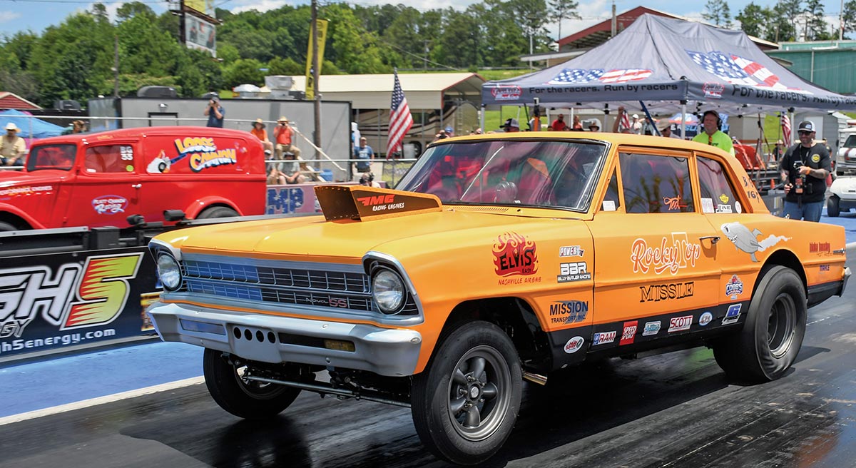 Yellow Chevy II gasser staging at the line.